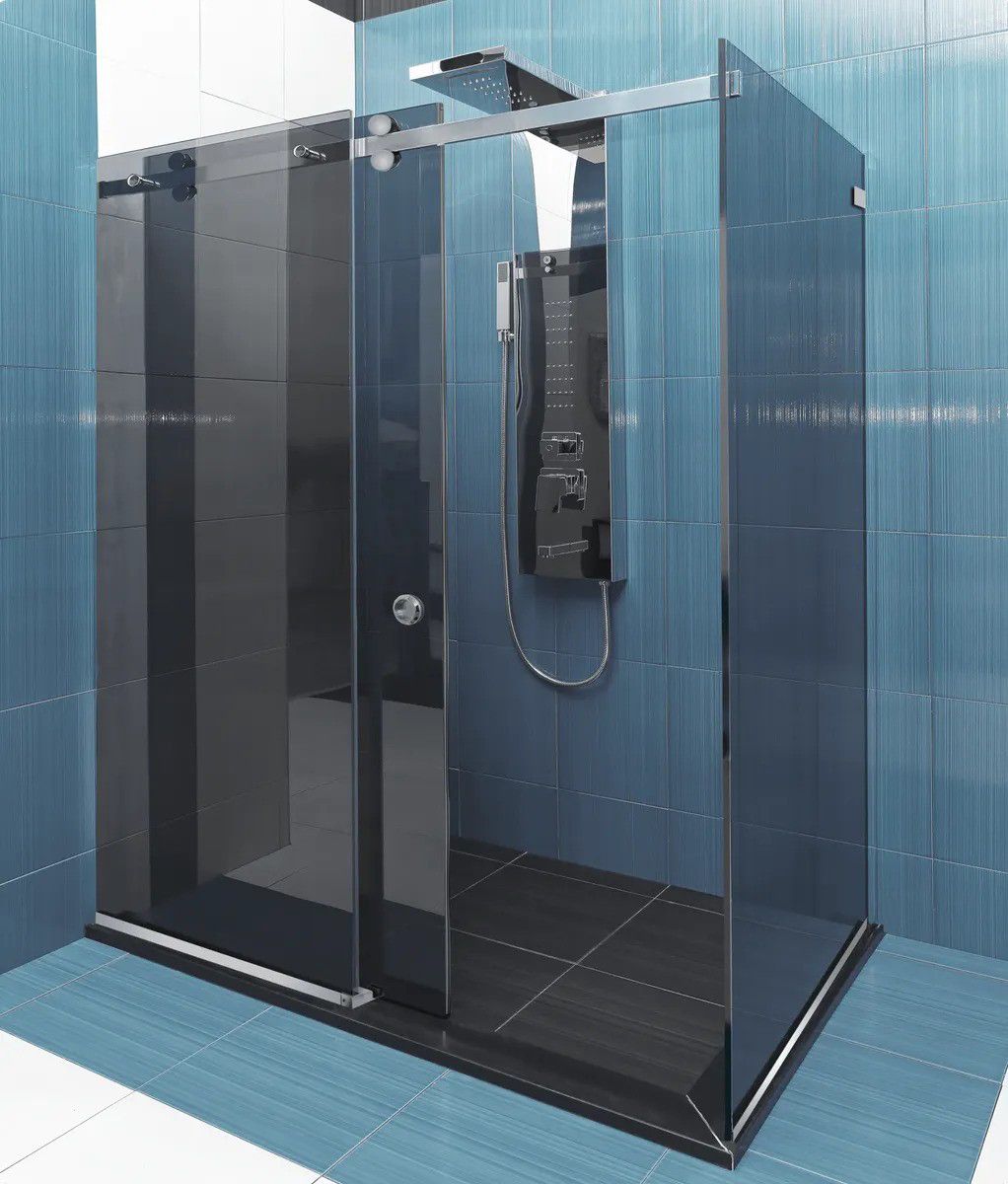 A bathroom with blue tiles and a shower stall with sliding glass doors