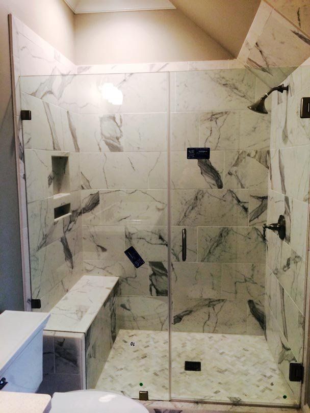 A bathroom with marble tiles and a walk in shower
