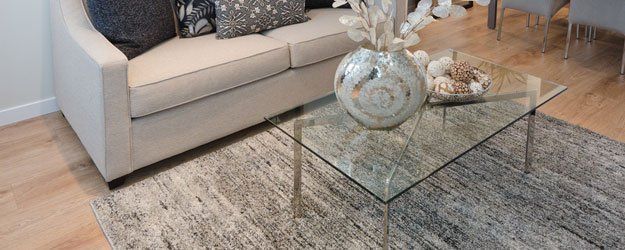 A living room with a couch and a glass coffee table.