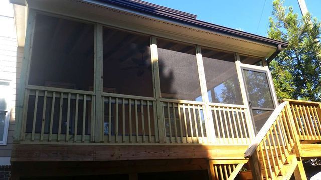 A screened in porch with stairs leading up to it