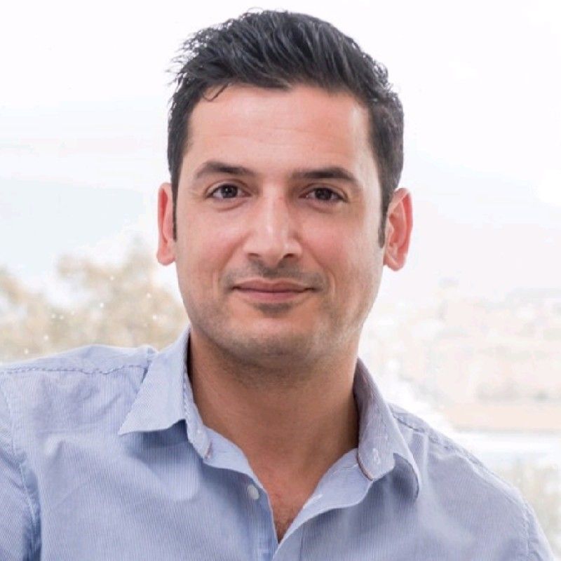 A man in a blue shirt is smiling for the camera.