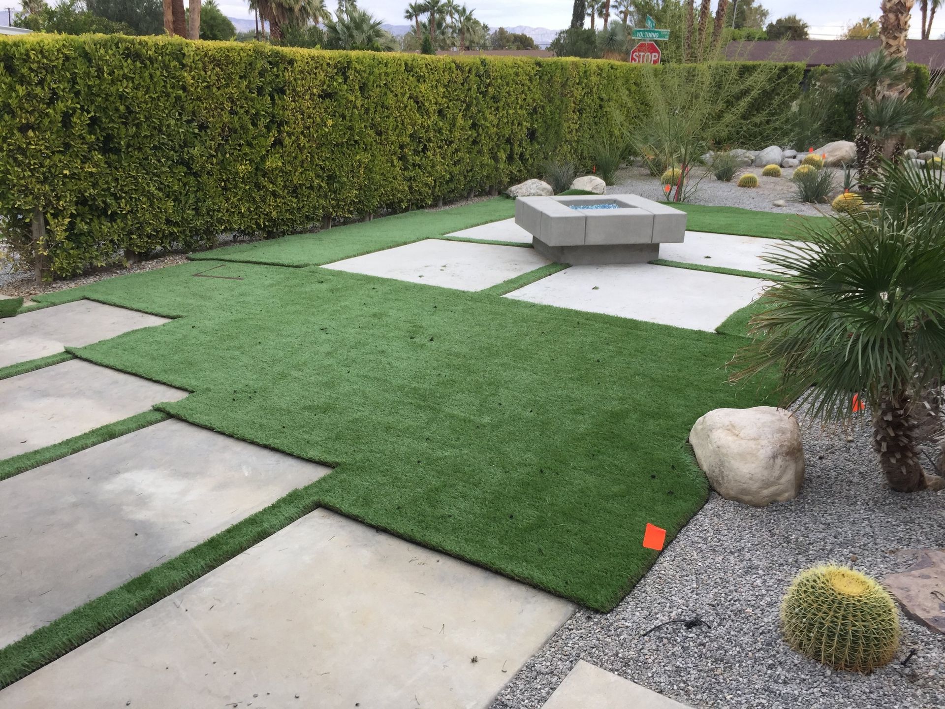 A lawn with a fire pit in the middle of it.