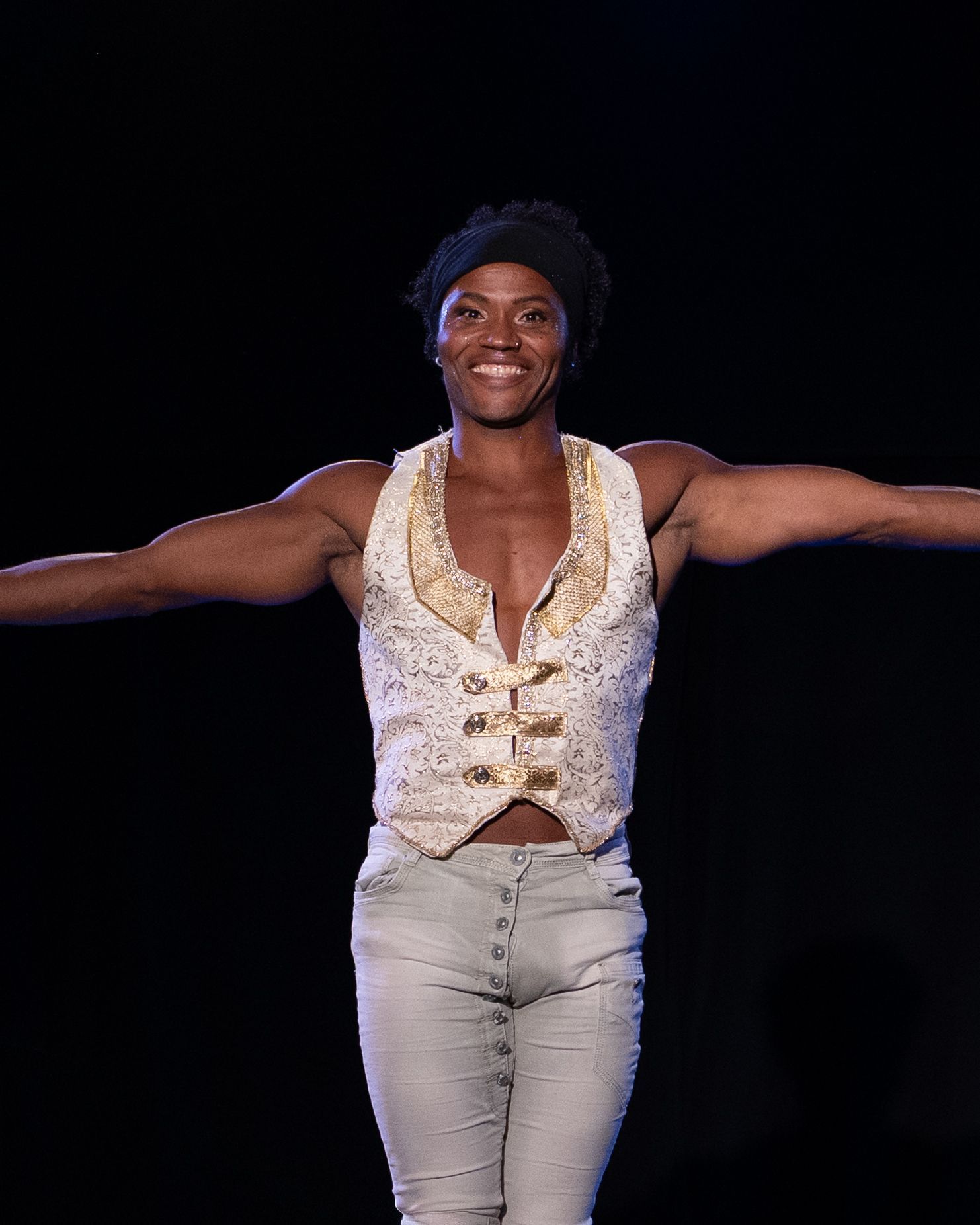 Giant butterfly performer in a street, illuminated by the sun, with people watching.