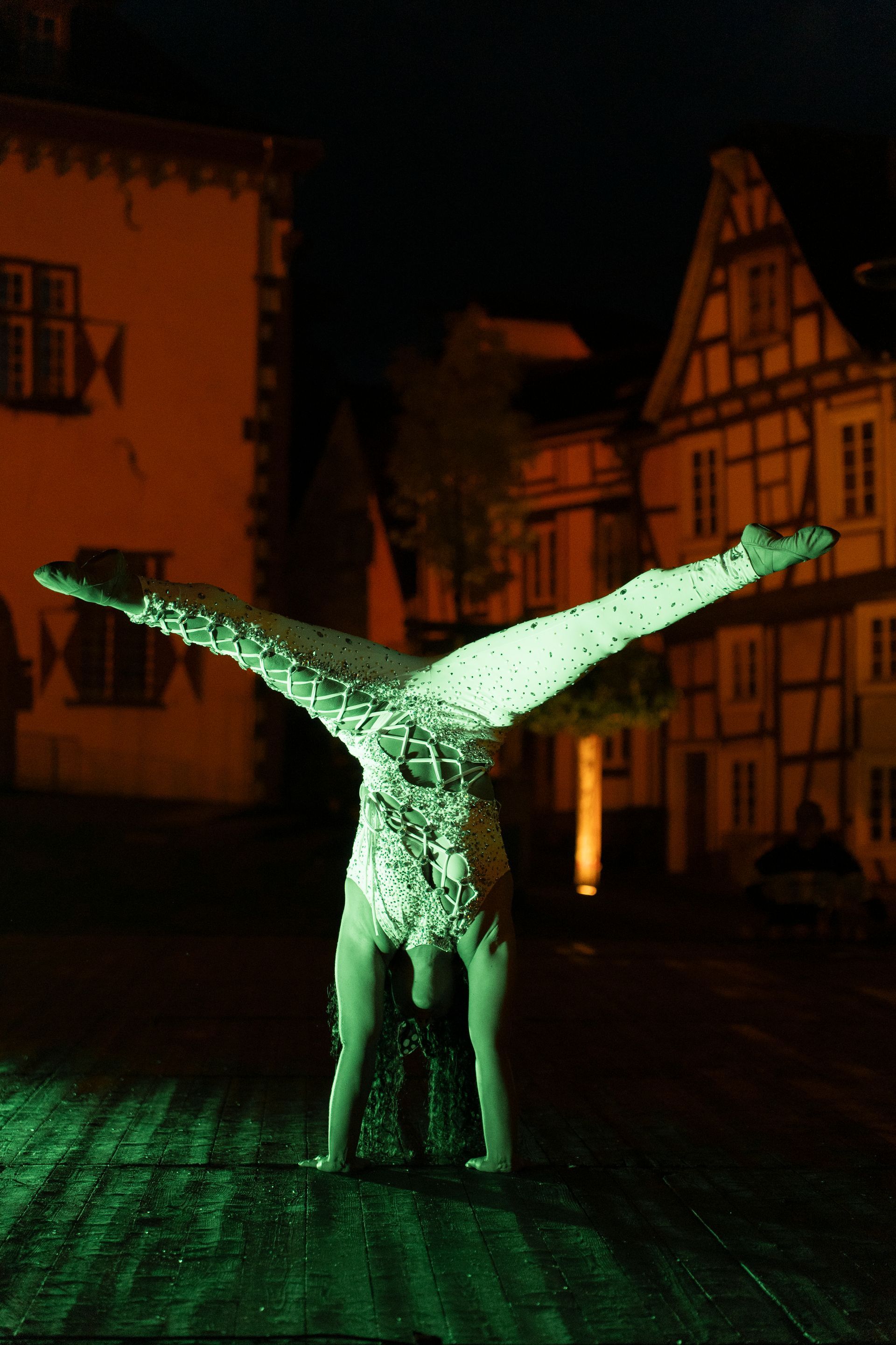 Street performers: stilt walker with butterfly wings, two women in fairy costumes doing cartwheels.