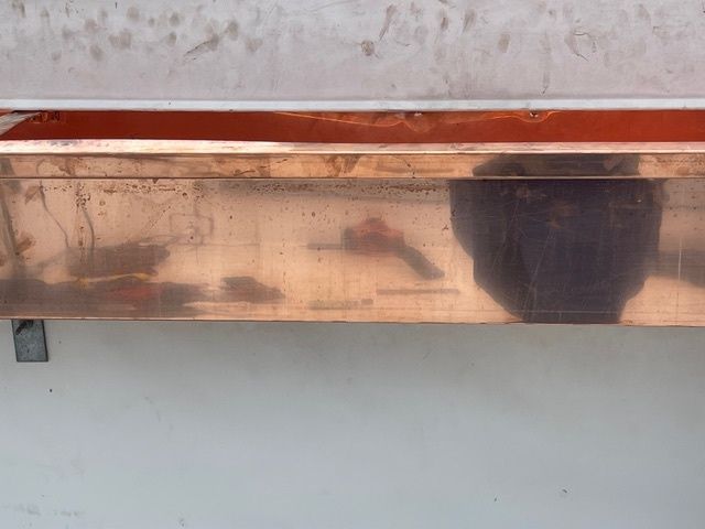 Wooden front door with sidelights, porch, and white pillars.