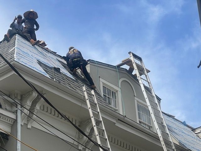 Bright white kitchen with stainless steel appliances, island, and overhead track lighting.