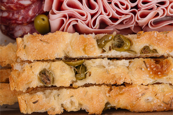 Tabla de embutidos con jamón lonchas, queso, hummus, almendras y aceitunas.