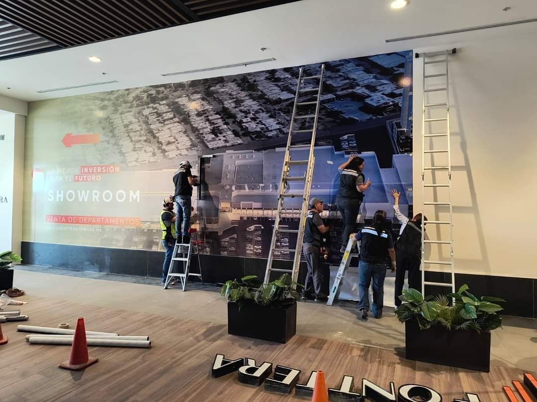 Un grupo de personas está trabajando en un gran mural de pared.
