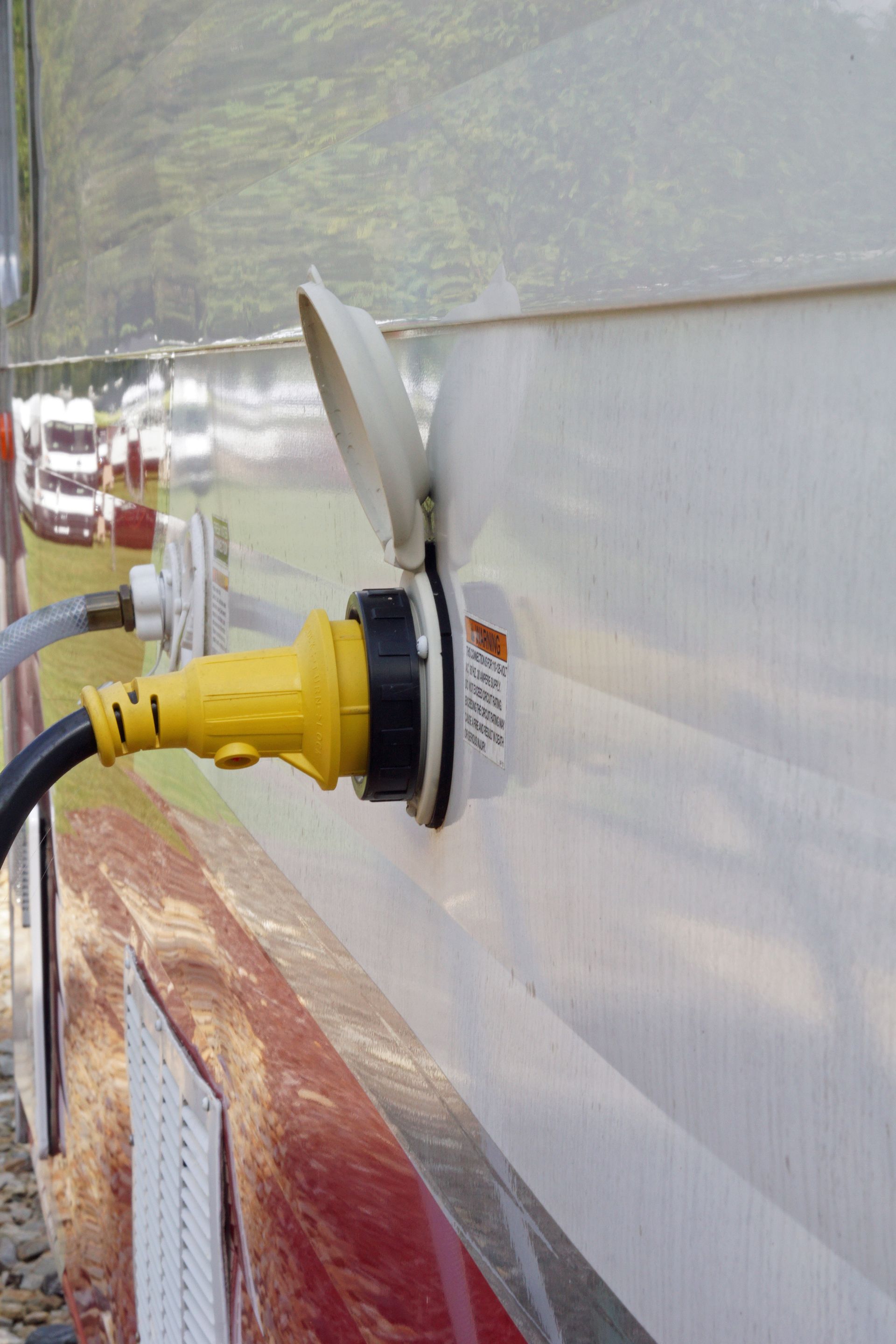 A yellow plug is plugged into a white wall.