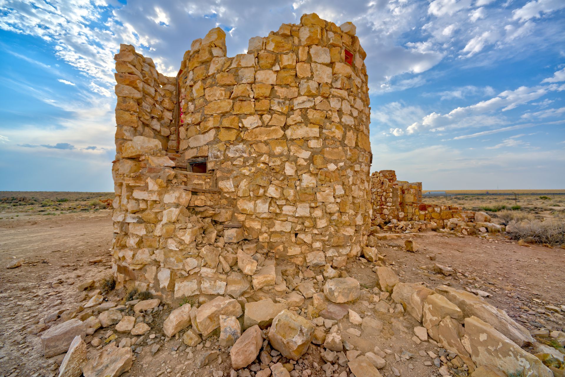 An old stone building in the middle of a desert.