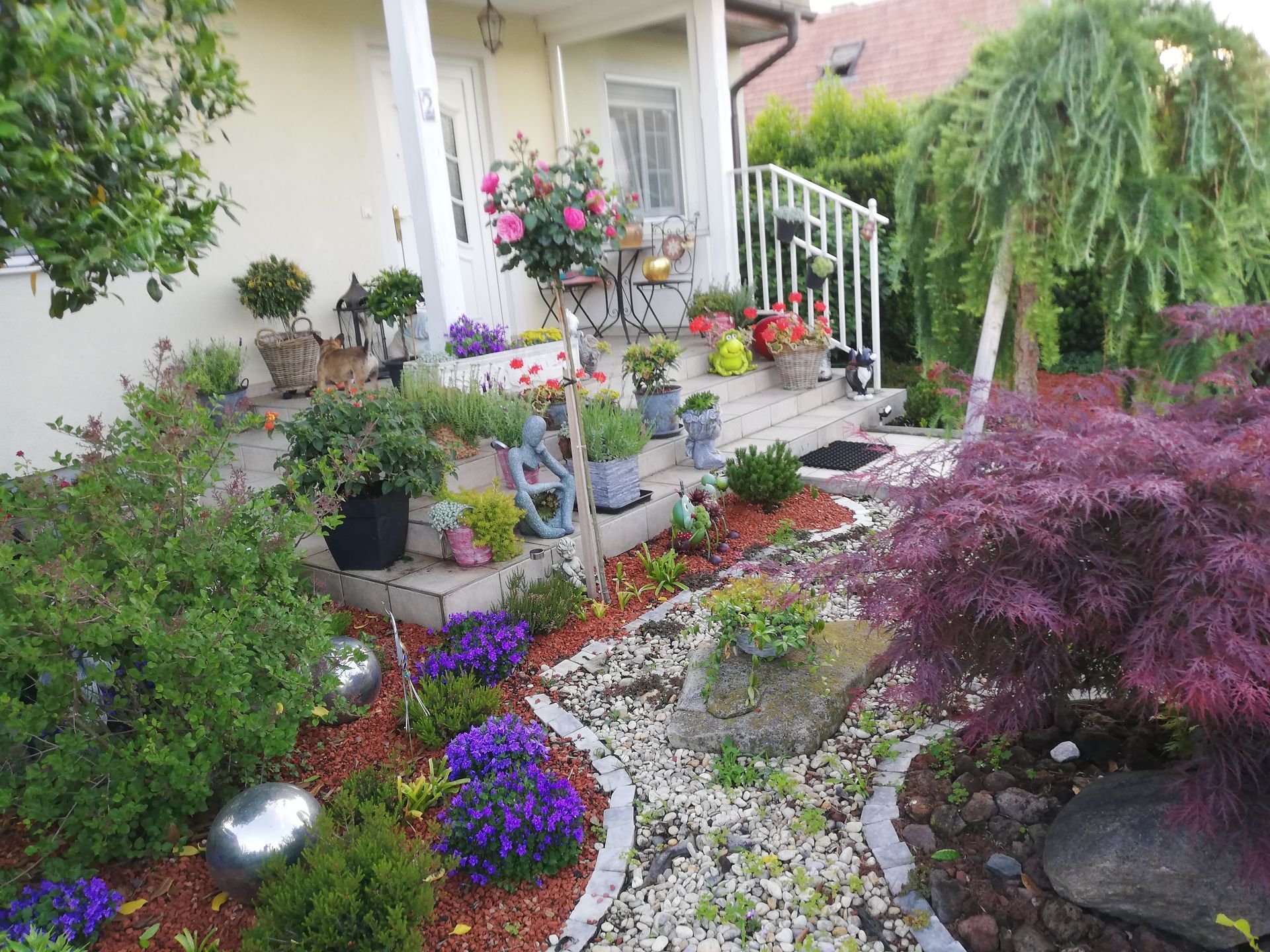 Tiki-Statue vor Bambuszaun umgeben von Pflanzen.