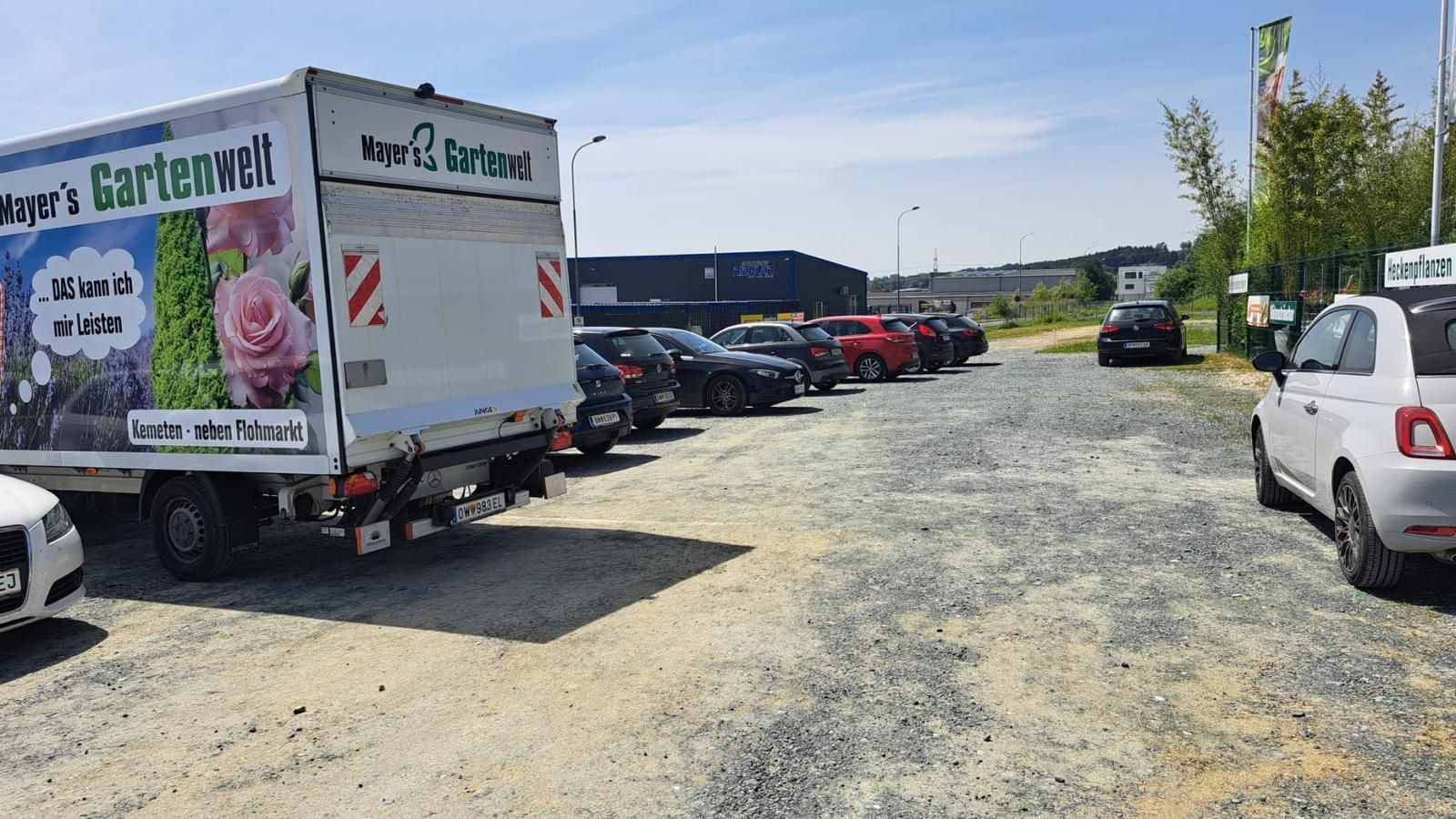 Ein weißer Lastwagen mit dem Bild einer Frau an der Seite steht auf einem Parkplatz.