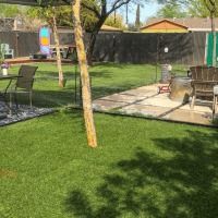 A backyard with a table and chairs and a fence.
