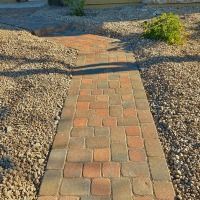 A brick walkway leading to a house in the desert.