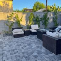A patio with a couch , chairs , and a table.