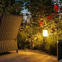 A patio with a chair and a lamp at night.