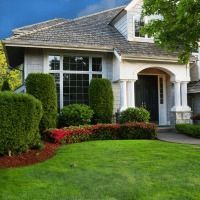 A large white house with a lush green lawn in front of it.