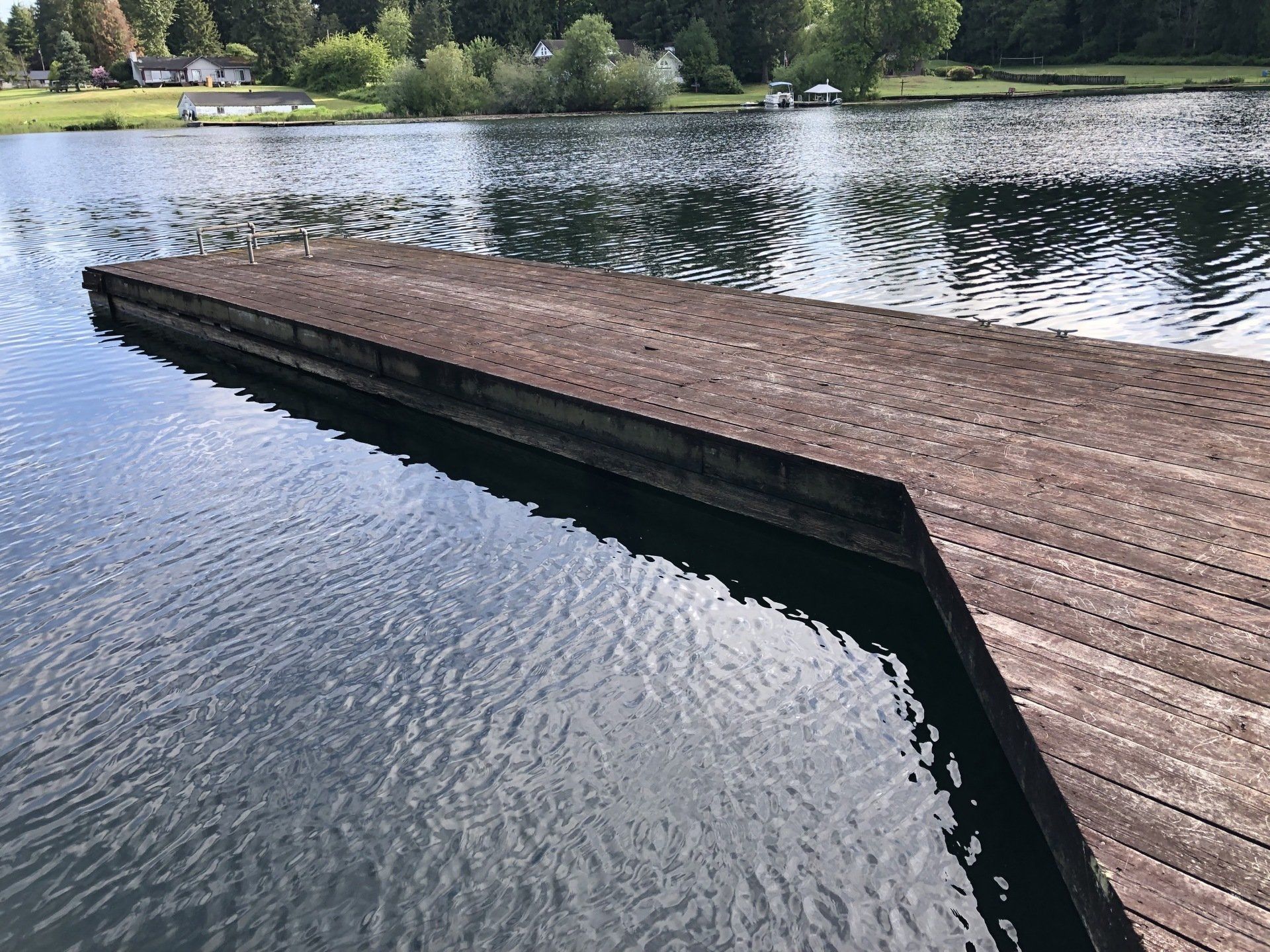 A wooden dock overlooking a lake with trees in the background