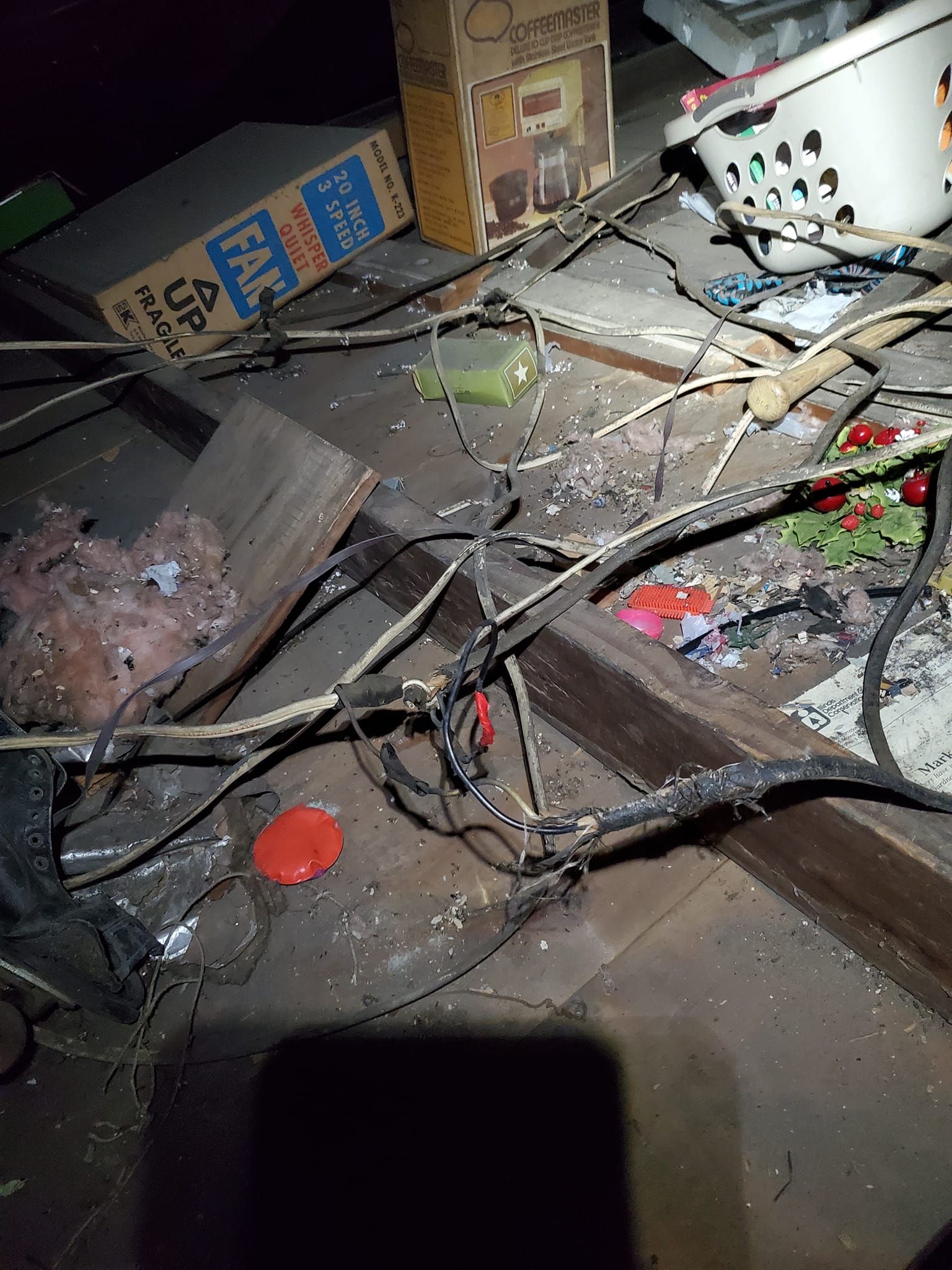 Woman in straw hat smiles, holding wine glass near a lake.