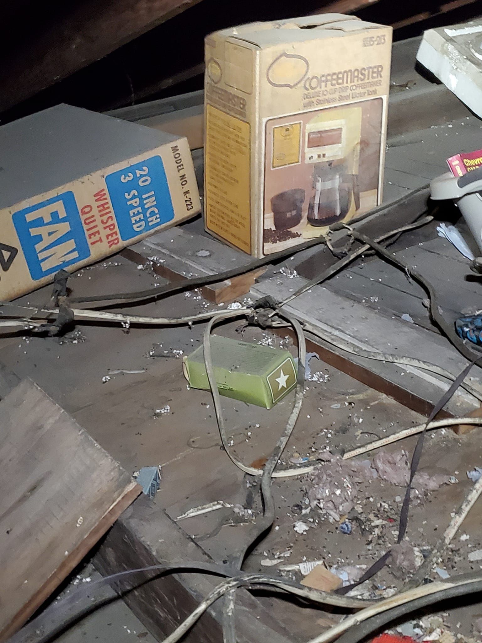 Woman in straw hat smiles, holding wine glass near a lake.