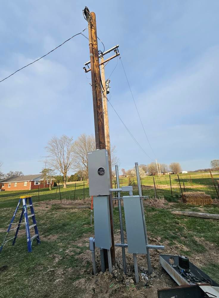 Woman in straw hat smiles, holding wine glass near a lake.