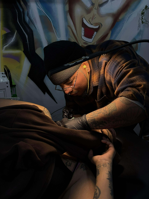 Man with a face tattoo and a head tattoo, white shirt, indoors.