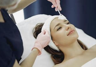 A woman is getting a facial massage with her eyes closed.