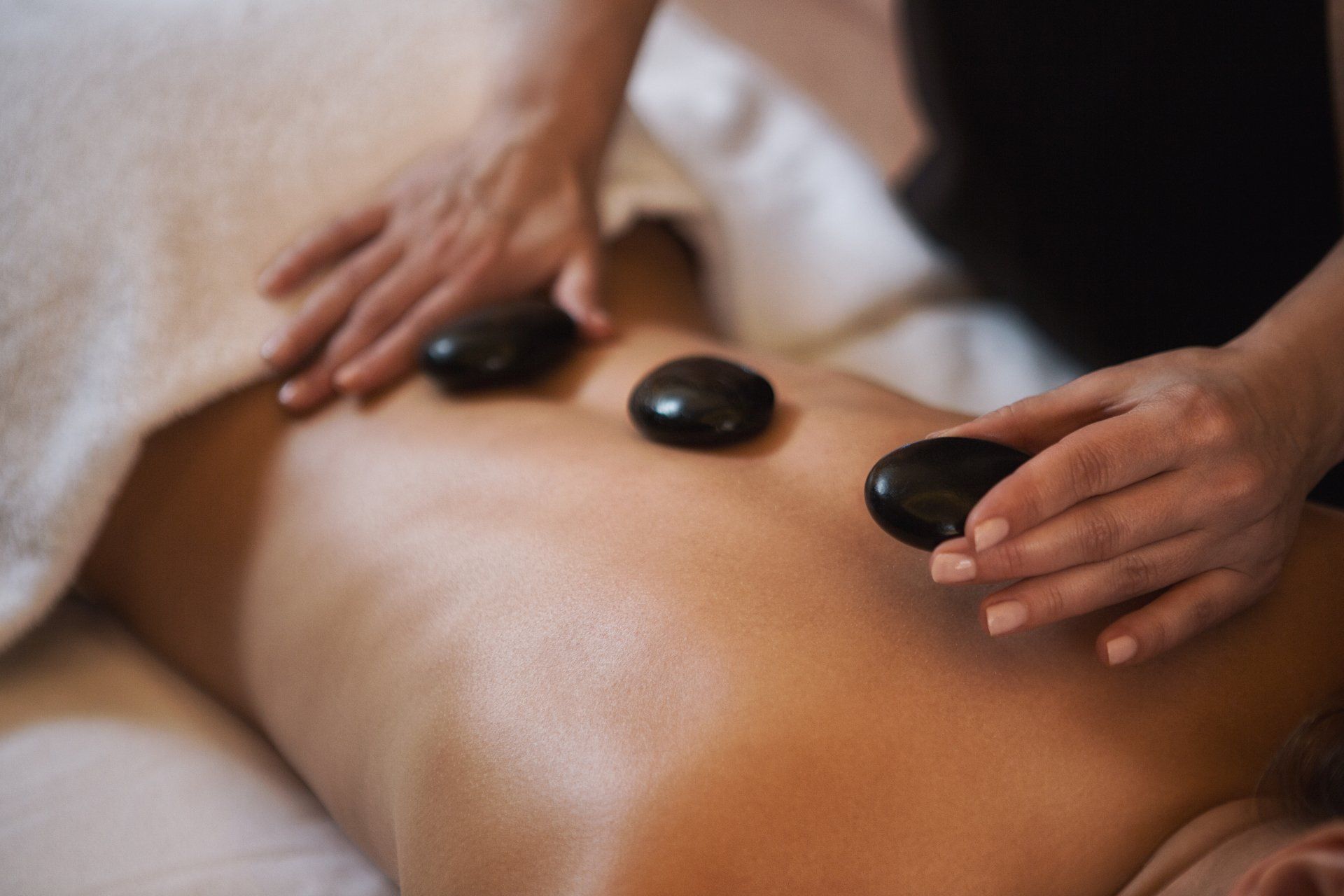 A woman is getting a hot stone massage at a spa.