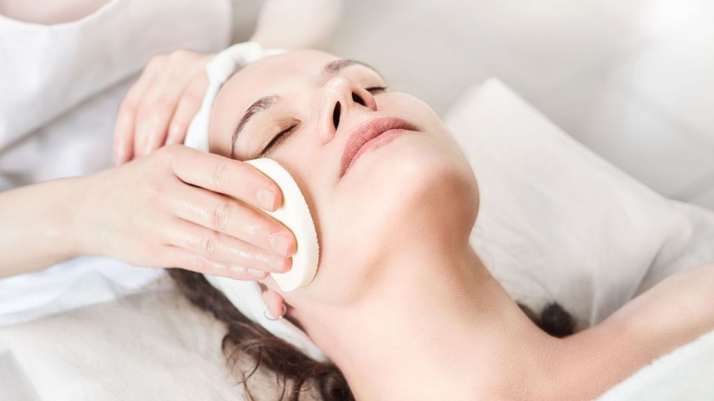 A woman is getting a facial treatment at a spa.