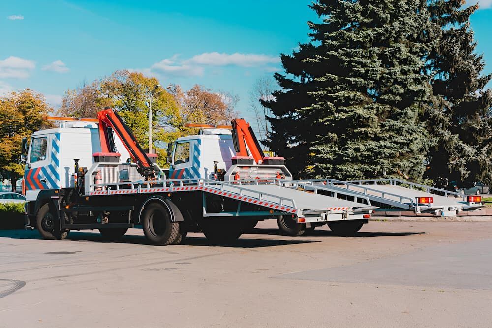 A Row Of Tow Trucks Are Parked In A Parking Lot — Ollies Towing & Shipping Container Sales in Maidenwell, QLD