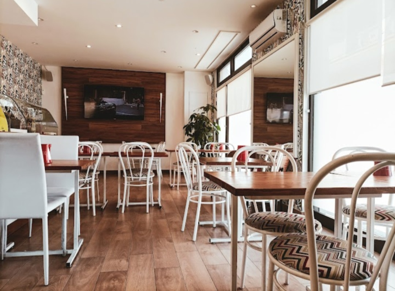 Un ristorante con tavoli e sedie e una televisione sul muro.