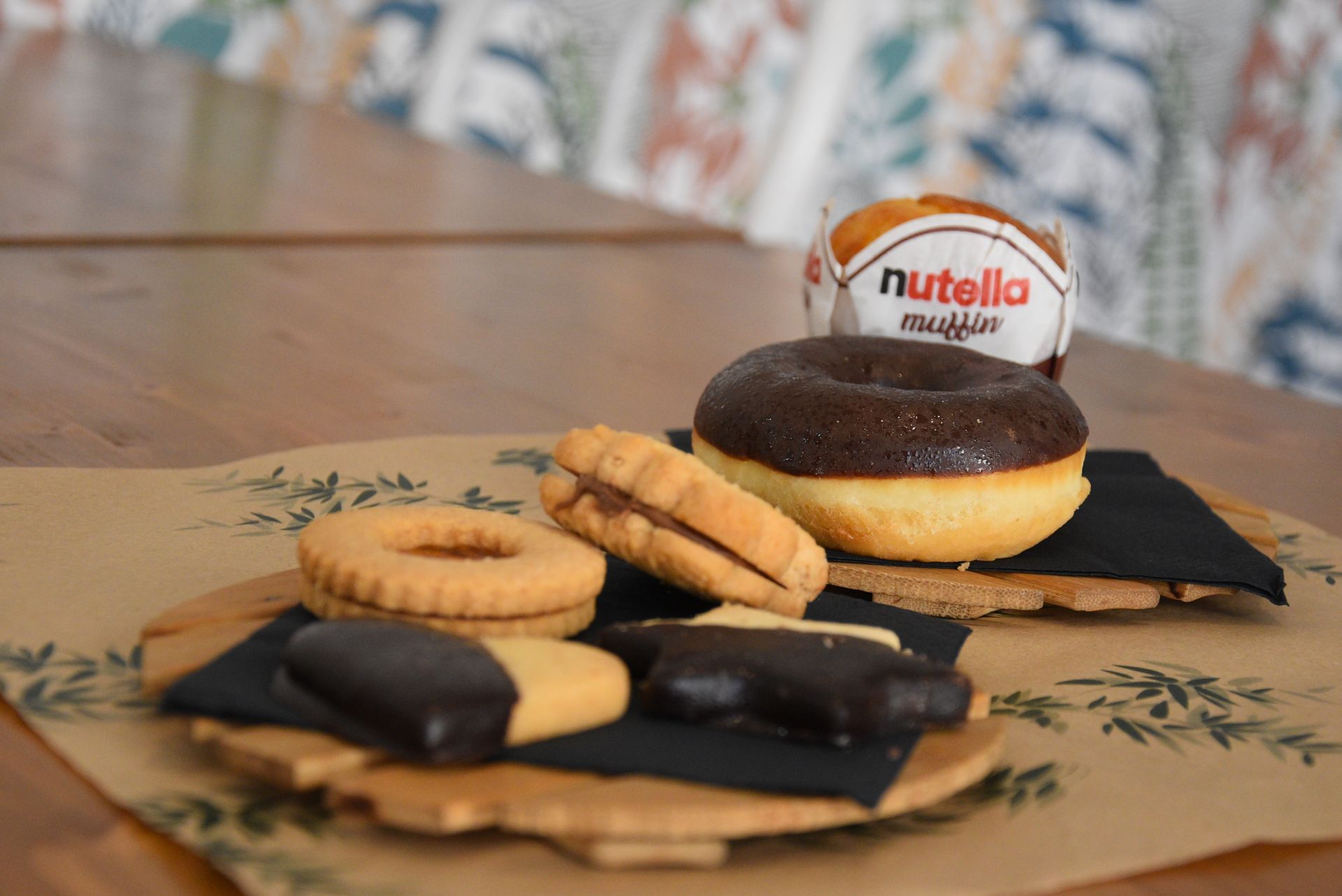 Un tavolo decorato con una varietà di biscotti e ciambelle, tra cui una ciambella alla nutella.