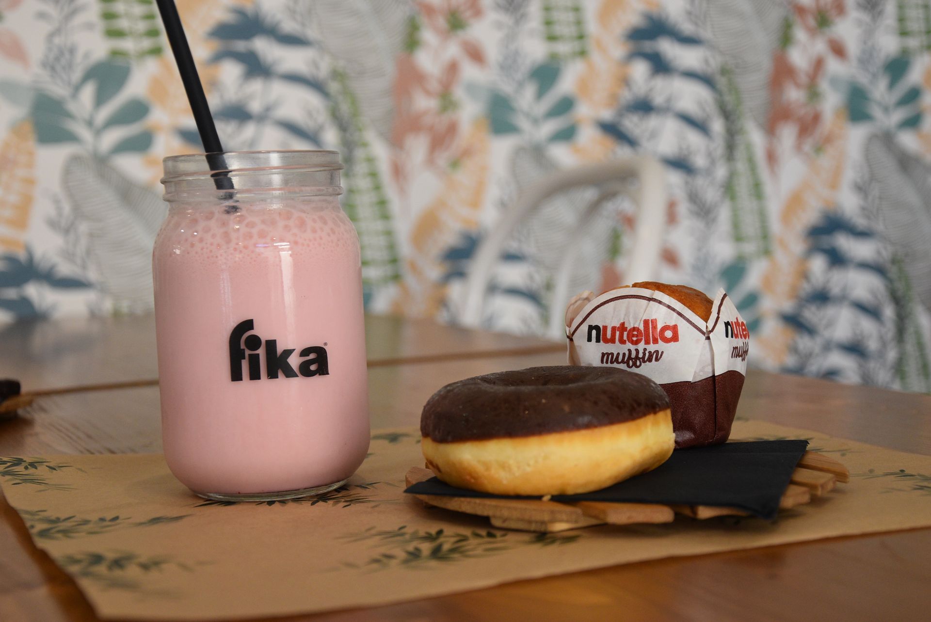 Un frullato alla fragola e una ciambella al cioccolato sono su un tavolo.