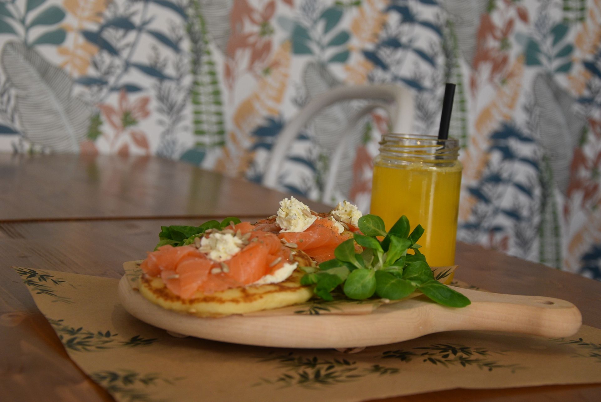 Un piatto di cibo e un bicchiere di succo d'arancia su un cucchiaio di legno su un tavolo.