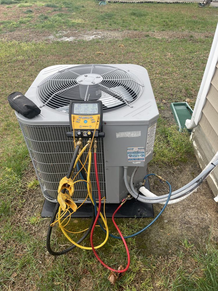 An air conditioner is being serviced by a plumber.