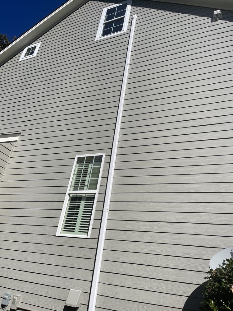 A house with a very tall chimney on the side of it.