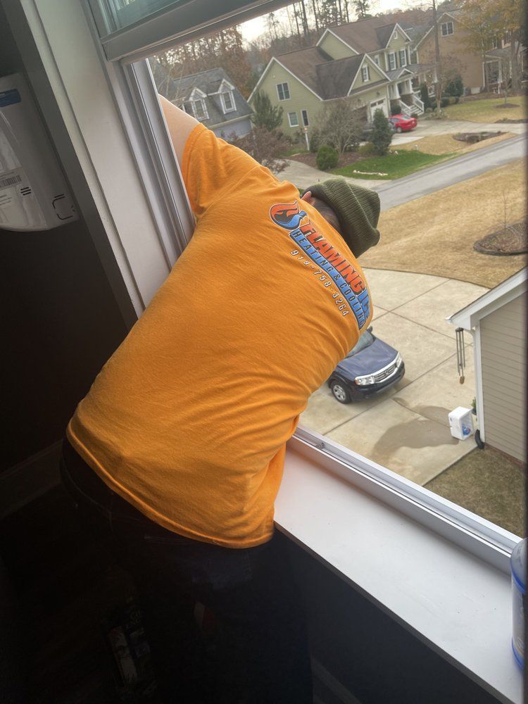 A man in a yellow shirt is looking out a window