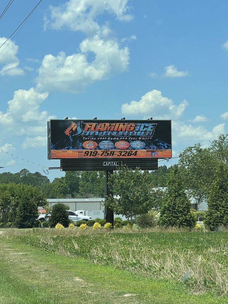 A large billboard is sitting in the middle of a grassy field.