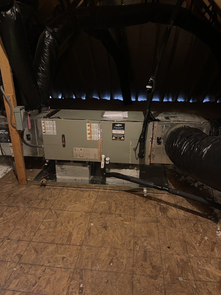 An air conditioner is sitting in the attic of a house.