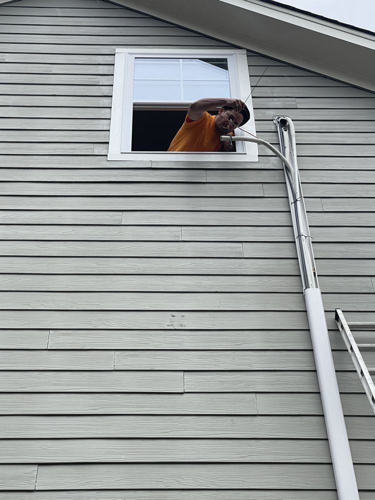 A man is looking out of a window on the side of a house.