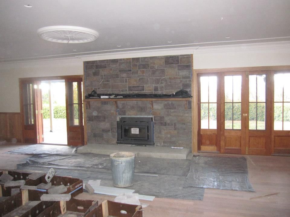 An empty room with a stone fireplace and wooden doors