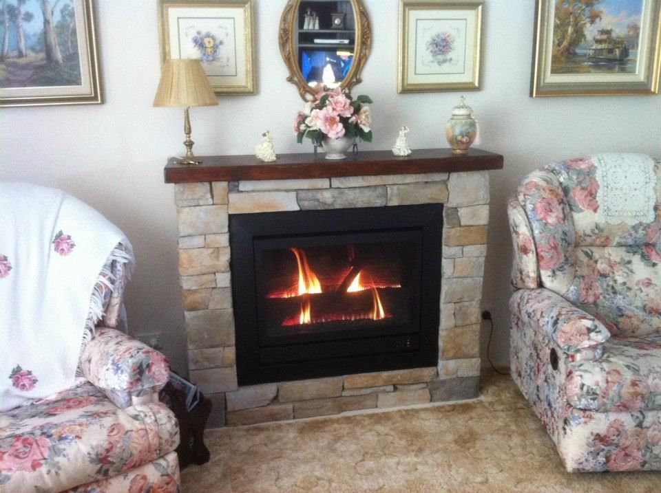 A living room with a fireplace and two chairs