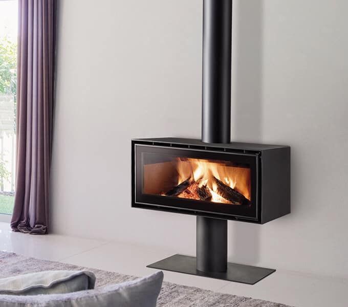 A fireplace in a living room with purple curtains