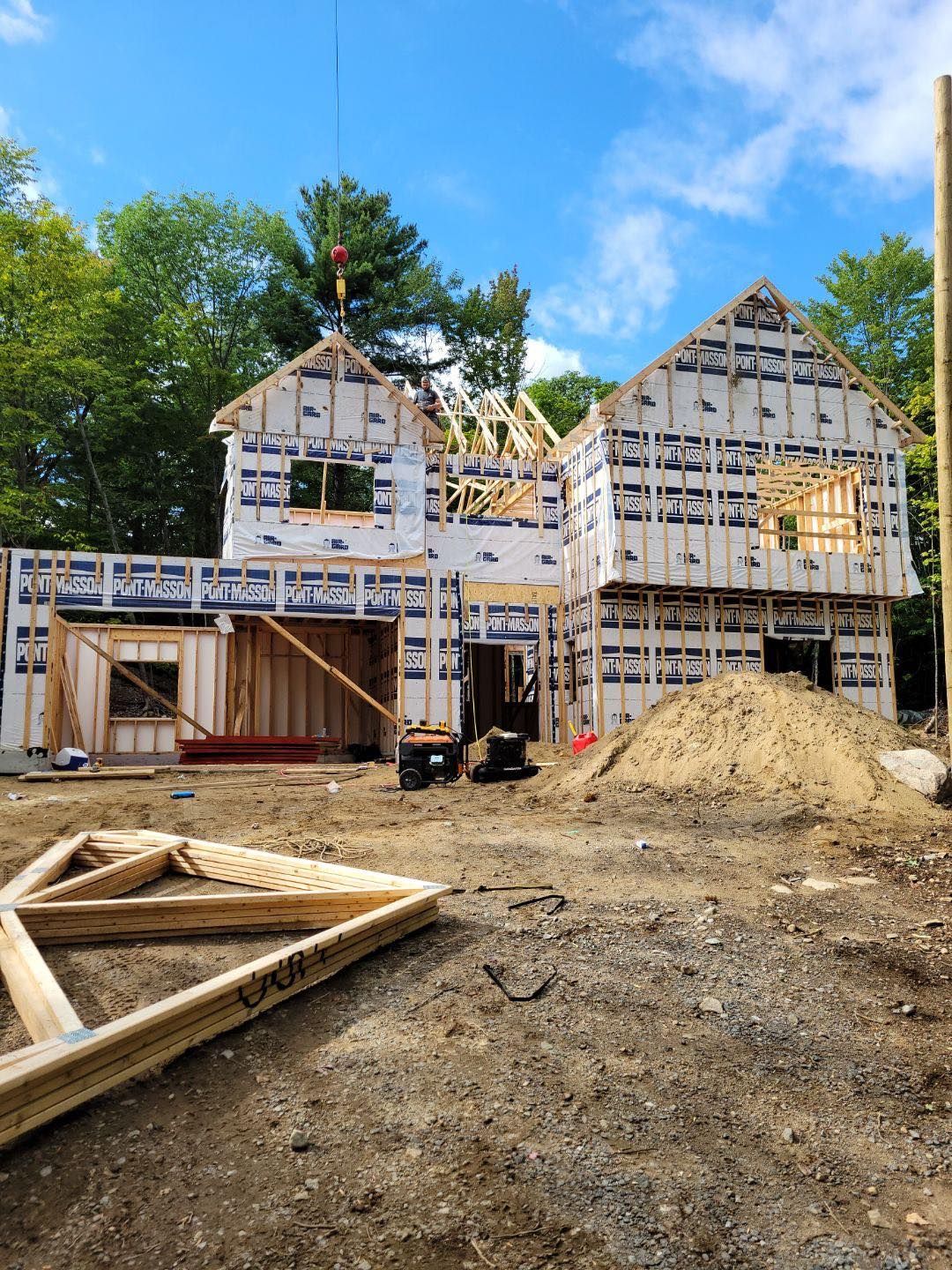 Une grande maison est en construction au milieu d'un champ de terre.