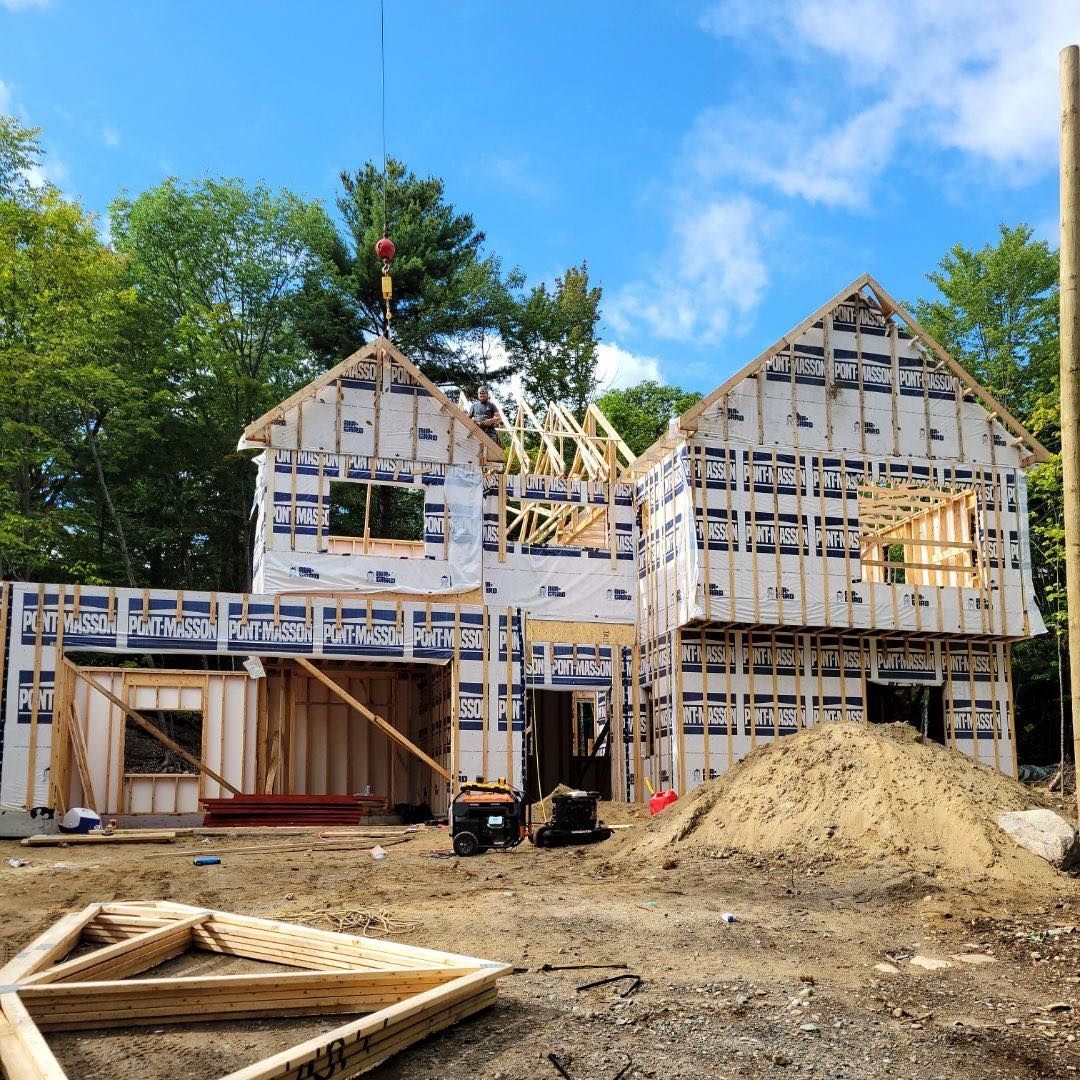 Une maison est en construction au milieu d'un champ de terre.