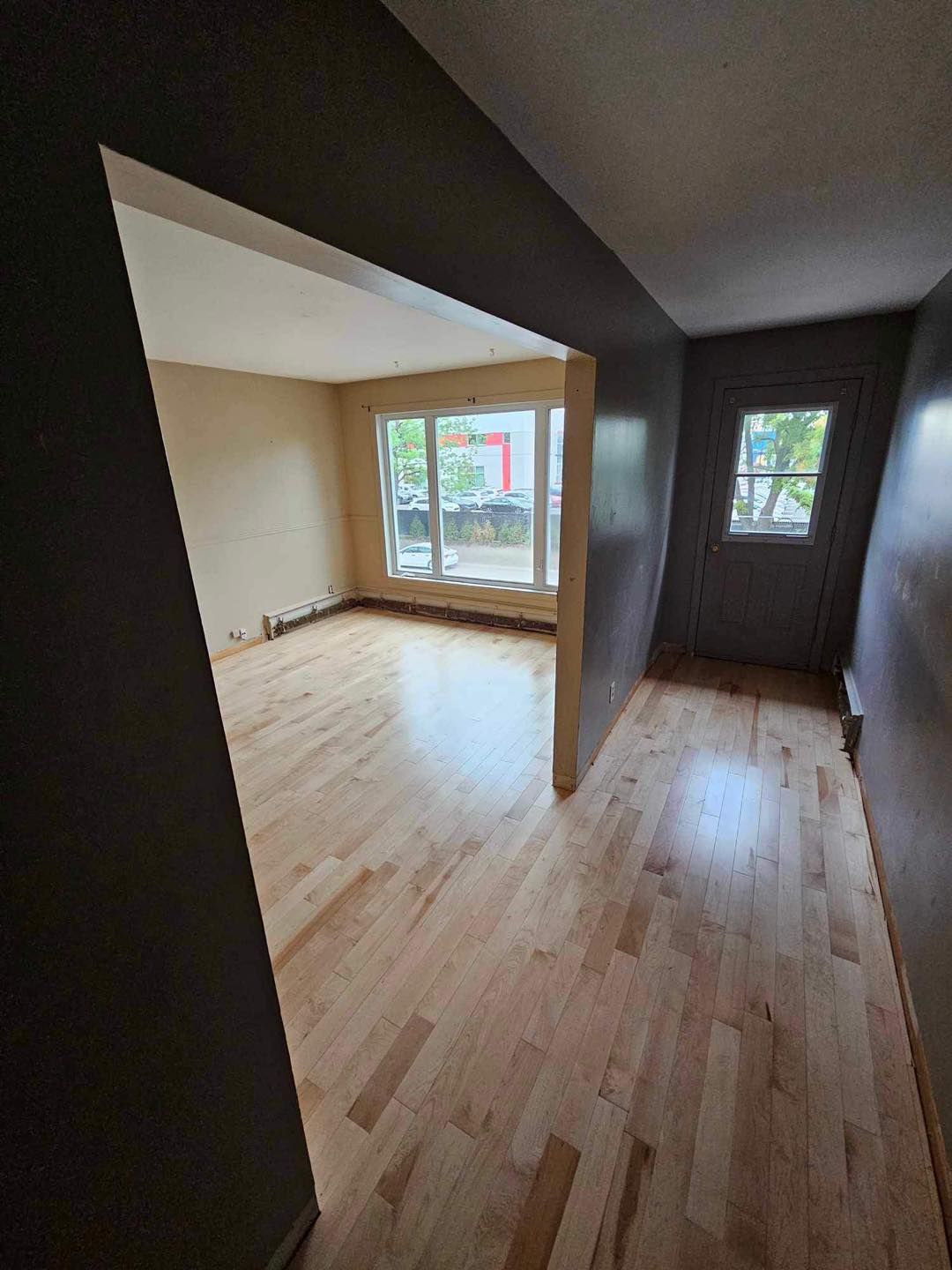 Une pièce vide avec du parquet et une fenêtre.