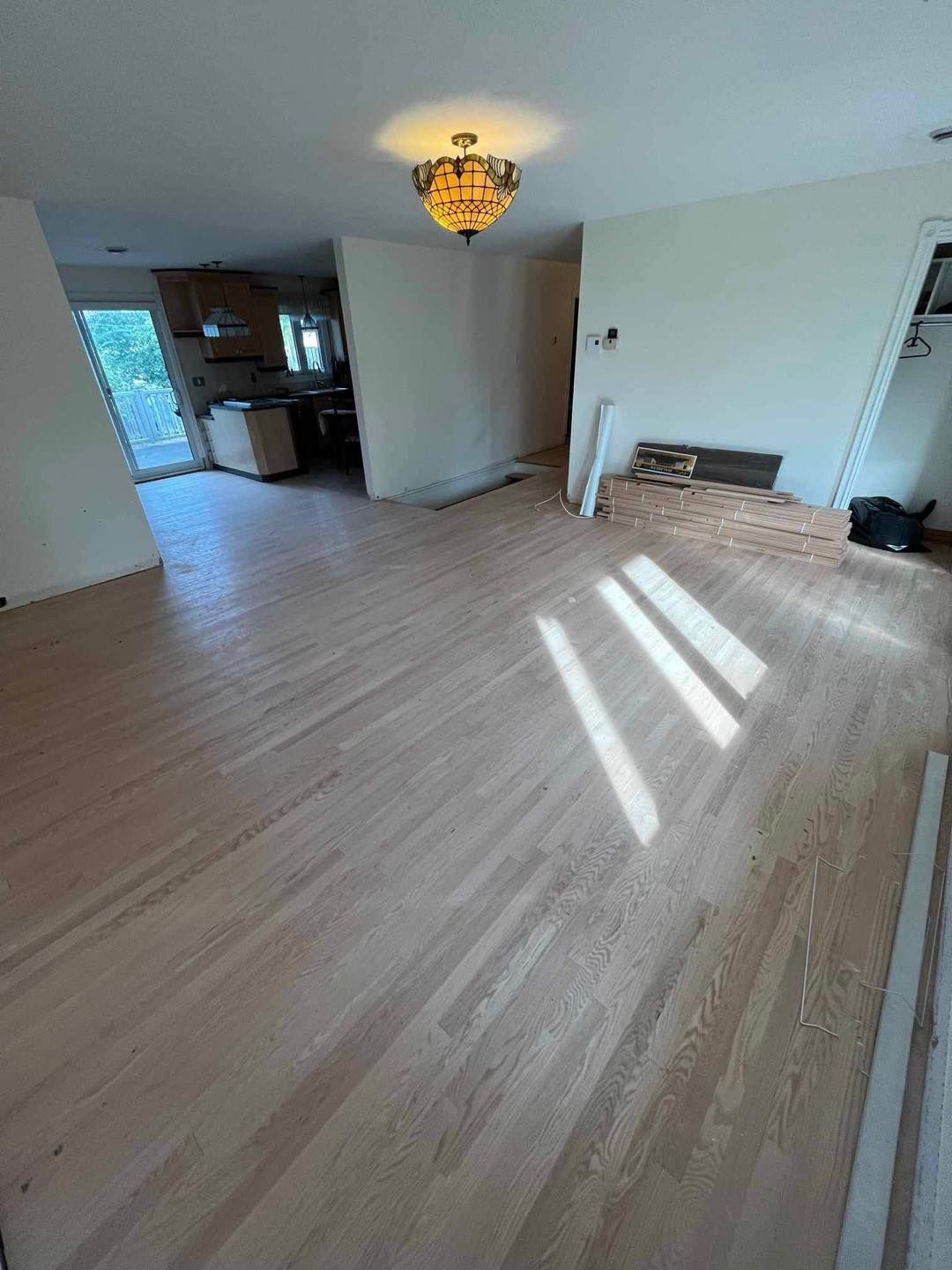 Un salon avec parquet et un lustre.