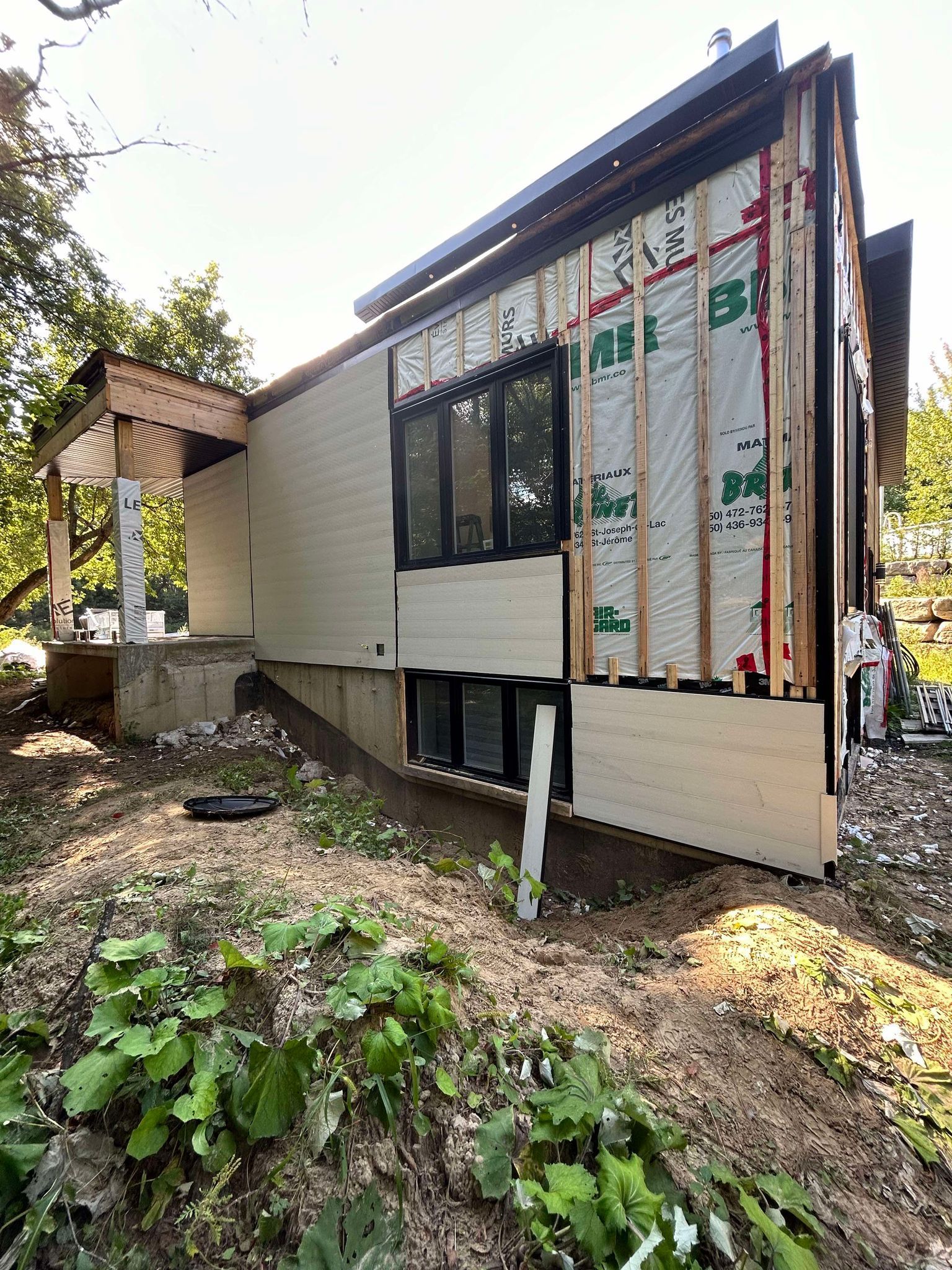 Une maison est en construction sur une colline avec beaucoup de fenêtres.