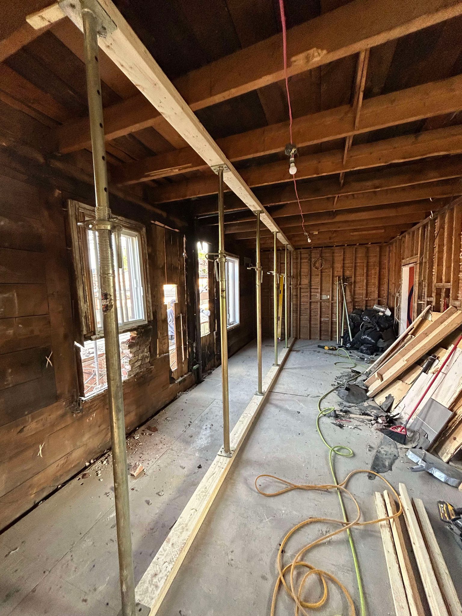 Une pièce avec beaucoup de poutres en bois et un tas de fils suspendus au plafond.