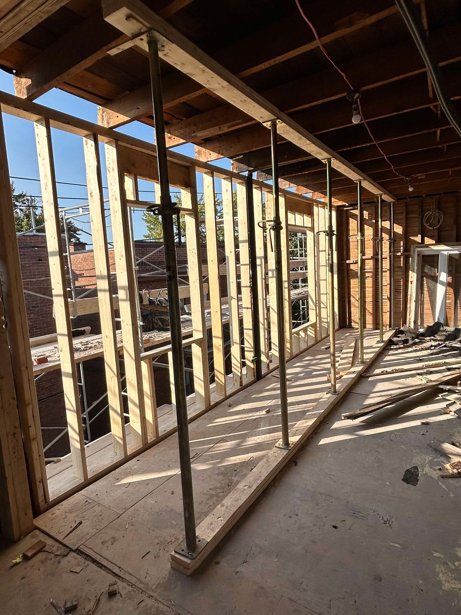 Un bâtiment est en cours de construction avec des poutres en bois et des échafaudages.